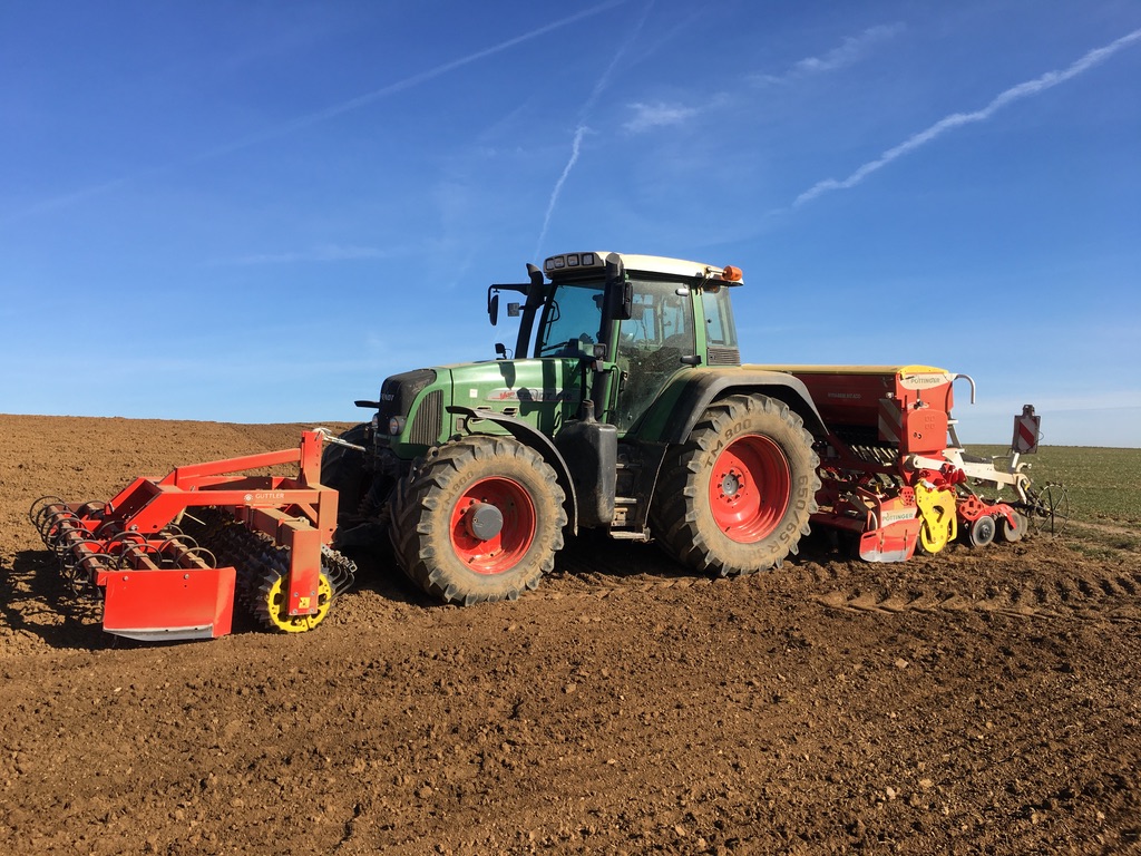 Traktor bei der Aussaat auf dem Gäuhanf Feld